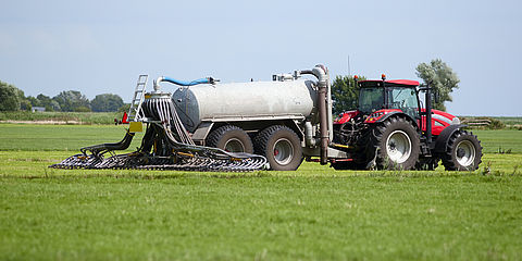 Traktor verteilt organischen Dünger auf einem Feld