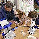 WESSLING Experte Frank Peterskeit erklärt Kindergartenkindern das Mikroskop