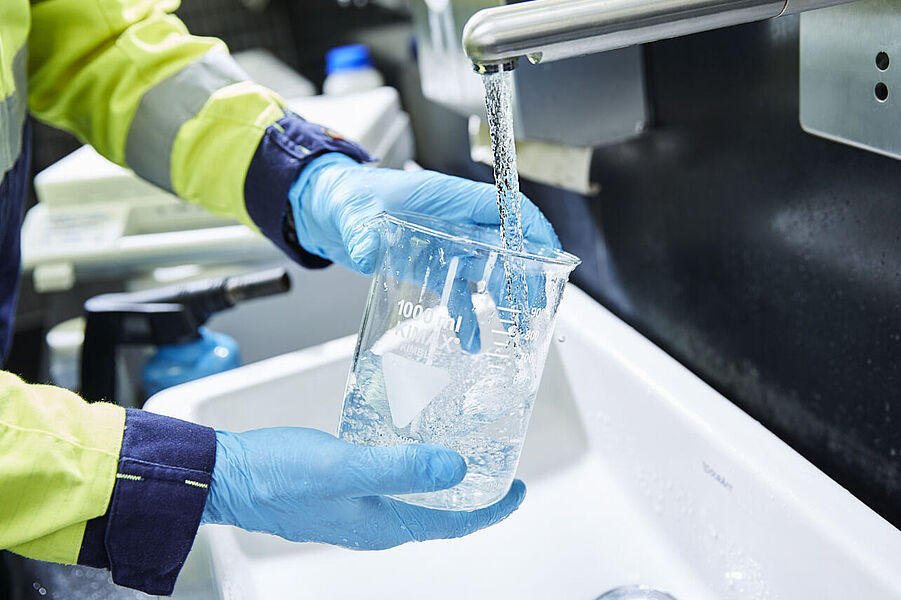 WESSLING nimmt eine Wasserprobe aus einem Wasserhahn.