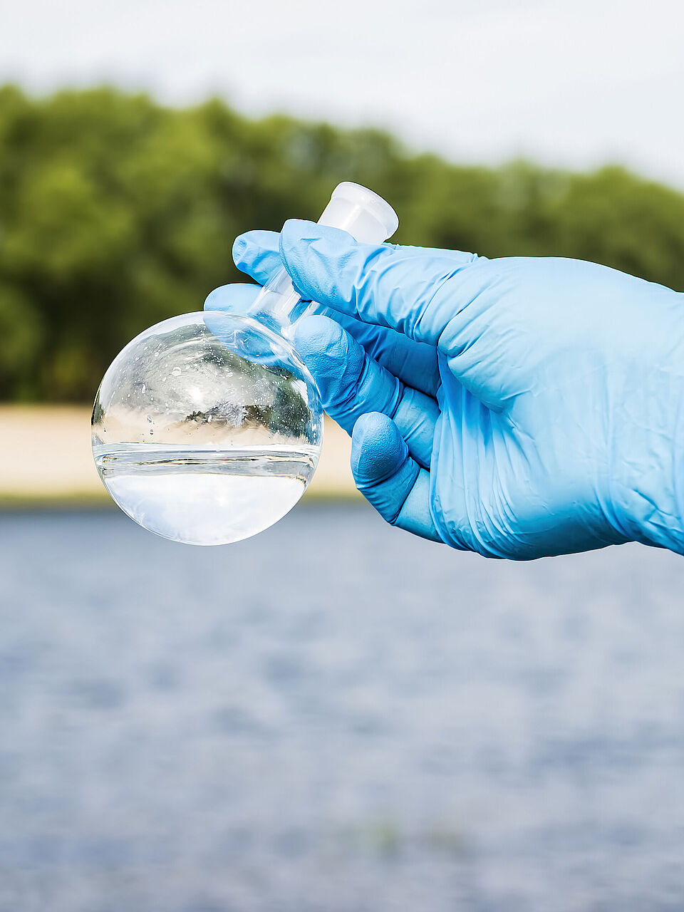 WESSLING Probenehmer hält Wasserprobe in der Hand - Analytik und Beratungsdienstleistungen laufen bei WESSLING Hand in Hand.